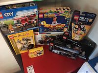 Group shot of eight sealed LEGO sets on red surface