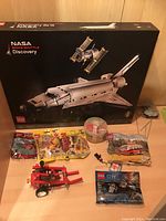 Front view of sealed LEGO NASA Space Shuttle Discovery box with polybags and assembled parts in front