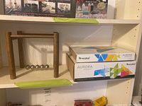 Shelf display showing Newton’s cradle and two Nanoleaf boxes