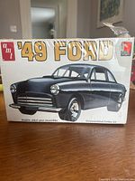 Box front showing illustration of customized 1949 Ford in black. AMT logo and model scale 1:25 indicated.