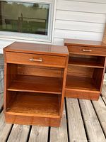 Two wooden night stands side by side showing front and side profile with drawers and shelves.