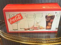 Original box showing set of 8 Coca-Cola Bell Soda Glasses with 16 oz capacity in Georgia green glass.