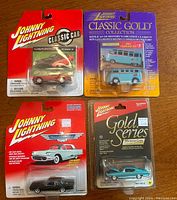 Four Johnny Lightning die-cast classic cars in sealed packaging displayed on surface. Cars include Muscle Cars, Classic Cars, and Classic Gold Collection series.