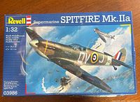 View of the front of the model kit box showing the illustration of the Spitfire Mk. IIa and branding, with visible box damage and wear.