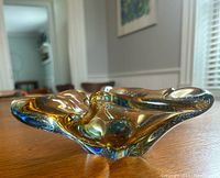 Side angle showing the shape and bubble texture in the blue and amber glass dish.
