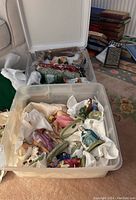 Plastic bin with wrapped ceramic Nativity figurines including both sets