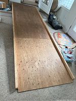 Photo of the longer wooden wheelchair ramp measuring approximately 12 feet long and 44 inches wide, showing plywood surface and wooden side rails.