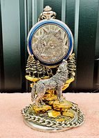 Front view of pocket watch on wolf-themed stand showing detailed wolf face and gold-plated accents