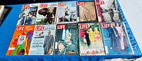 Photo showing 10 vintage LIFE magazines arranged in two rows with colorful covers including Beatles and other notable themes