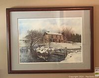Framed limited edition print, winter house scene with snow and water, seen hung on wall