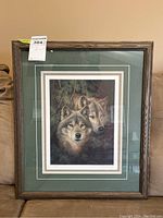 Framed artwork of two wolves labeled as lot, showing overall condition and presentation