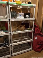White resin shelving unit with four slatted shelves shown with various items on it and in empty condition.