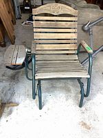 Front view of wood slider chair showing wood slat backrest with floral detail and attached oval side rack