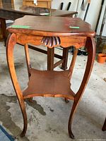 Photo of wood table front showing bowed legs and carved apron