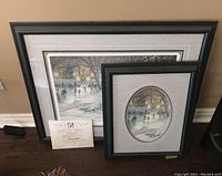 Two framed prints by Trisha Romance shown side by side, with Certificate of Authenticity in front of larger print.