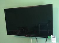 Front view of black LG flat screen TV mounted on wall.
