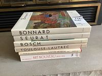 Stack of six hardcover art books with titles for Bonnard, Seurat, Bosch, Toulouse-Lautrec, Louvre Museum Old Master Paintings, and Art Nouveau 1890-1914.