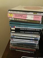 Stack of classical music CDs with titles visible such as David Oistrakh concertos, Atlanta Symphony Orchestra, and other orchestral recordings