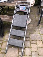 Top view of the three-step ladder showing textured steps and tool tray area.