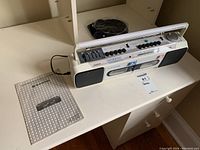 Sanyo M W737 stereo unit sitting on white desk, with user manual and headset nearby