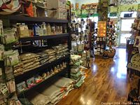 Store interior showing shelves stocked with various bird seed bags, feeders, and nature-related products.