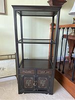 Full front view of the Korean wooden shelf showcasing the open shelving above and lower chest with cupboard doors, visible decorative brass accents and missing drawer pull on one drawer.