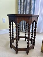 Side view of oak occasional table showing carved twisted legs and wooden apron.