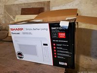 Boxed Sharp Carousel microwave oven with product image and details on the packaging.