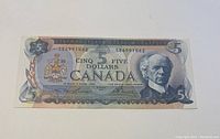 Front of the 1972 Canadian five dollar bill, showing the portrait of Sir Wilfrid Laurier and the Canadian coat of arms in clear detail.