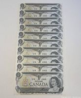 Ten sequential 1973 Canadian one dollar bills in mint uncirculated condition, arranged vertically in clear protective sleeves showing front of bills with serial numbers.