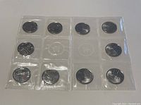 Front view showing sealed plastic sheets holding coins, mostly 10 and 25 cent coins from Canada 2012 Tecumseh series.