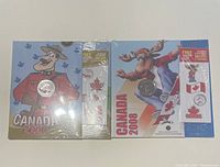 Two packages containing Canadian 25 cent coins from 2007 and 2008, each sealed, displayed with colorful Canadian themed artwork and collectibles.