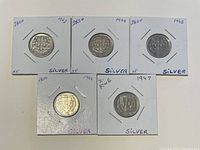 Five Portugal silver coins in holders showing obverse side with the shield and date (1943, 1944, 1945, 1947, 1949).