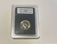 Obverse side of the 1976-D Washington quarter coin in protective slab, showing George Washington profile and certification label.