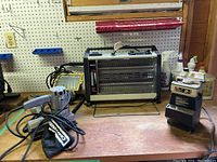 Wen wetstone sharpener machine, Marvin quartz heater, Craftsman sander, workshop work light on wooden workbench.