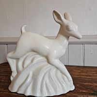 Front and side view of the white ceramic deer-shaped planter showing full figurine and textured base