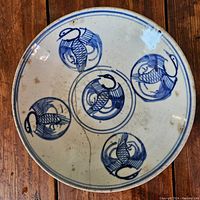 Top view of the Chinese porcelain bowl showing the hand-painted blue birds and visible aging and wear.