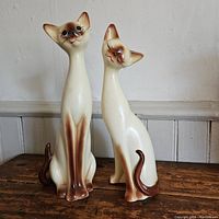Full front and side view of the pair of Siamese cat figurines showing size and form.