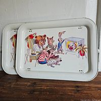 Two vintage metal TV trays stacked together showing the cartoon animal characters watching a TV.