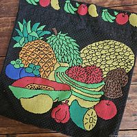 Front view of black beaded pillow case with multi-colored fruit beadwork depicting pineapple, papaya, banana, watermelon, apple, and more.