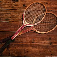 Pair of vintage wooden tennis rackets on wooden floor showing overall look and condition