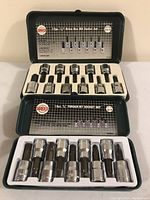 Two Sunco socket bit sets in open metal cases: a 12-piece 1/2" drive 6-point set and a 10-piece 3/8" torque bit set, both with chrome finish and white plastic trays.