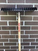 Front view of the thatching rake showing wooden handle with True Temper branding and metal tines.