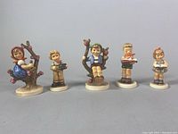 Front view of the set of five Goebel porcelain figurines showing various child characters and poses.