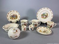 Full lot overview showing multiple Bunnykin porcelain items including plates, mugs, egg cups, oblong dish, and piggy bank.