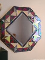 Octagonal stained glass mirror with copper edging, showing the geometric stained glass border and central reflective surface.