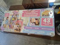 Box of KidKraft Champion Wood Dollhouse & Horse Barn showing branding, features, and included accessories.