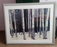 Front photo of a framed and matted winter aspen grove picture showing white-barked aspen trees with a dark forest in the background.