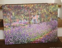 Photo showing the canvas print of Monet's Flower Garden, with visible impressionist style flowers and greenery, stretched on wood frame.