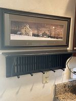 Photo showing black wooden shelf with vertical louvre slats and five hooks mounted on the wall below. Shelf measures about 30 inches wide as per seller.